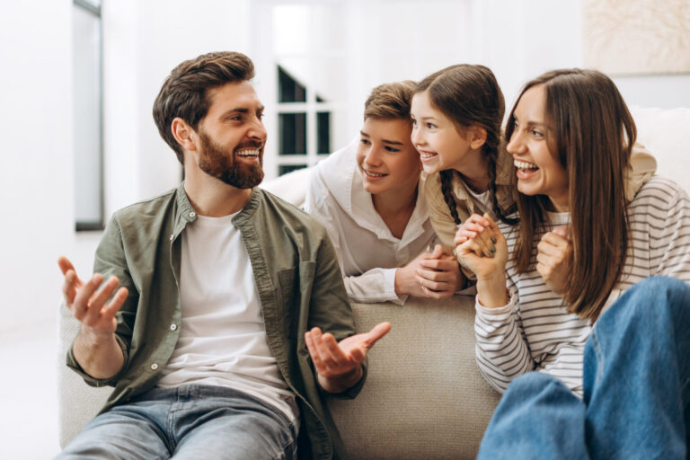 Happy family sitting together on a sofa discussing moving to a new home in Wigan