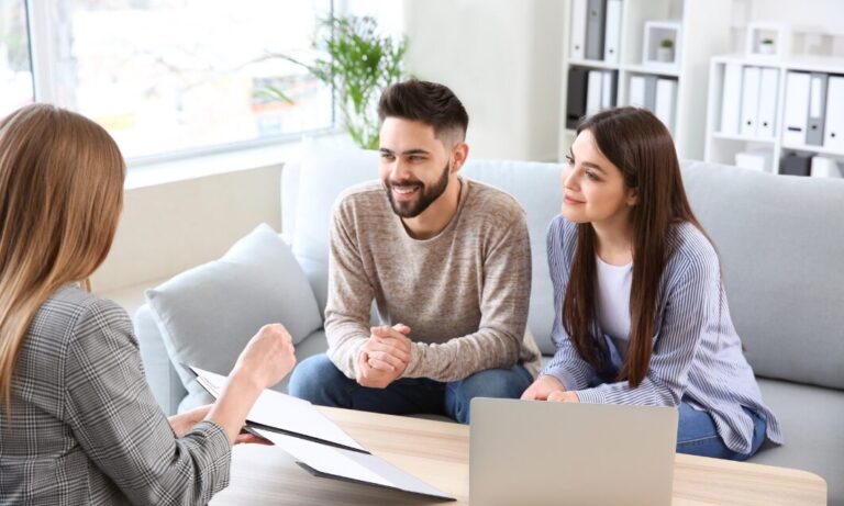Estate agent meeting with a couple to discuss selling, upsizing or downsizing their home in Cardiff’s CF14 postcode.