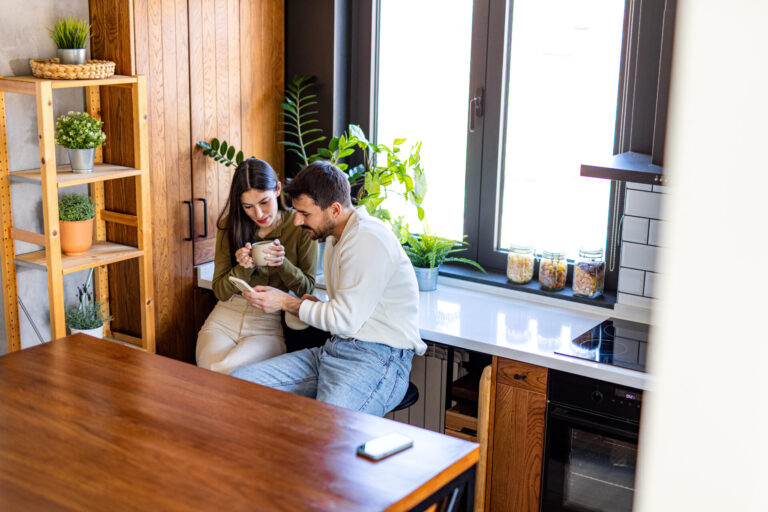 Couple looking at a phone together in a modern rental home in Haywards Heath