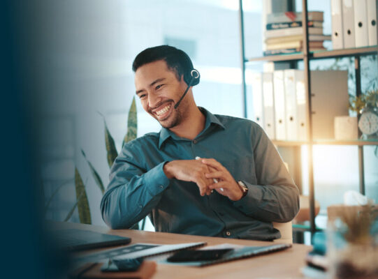 Happy businessman, consultant and laptop with headset for communication or online advice at office. Man, employee or friendly agent talking on computer with smile for virtual assistance at workplace.